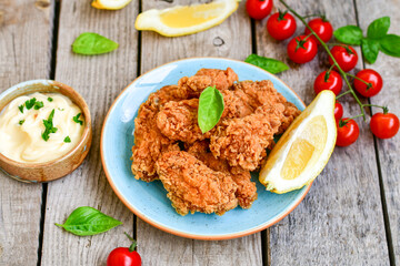 
 Crispy  deep Fried   Chicken strips and wedges potato. Breaded  with cornflakes chicken  Breast Fillets  with chilly peppers and fresh   basil on wooden rustic background