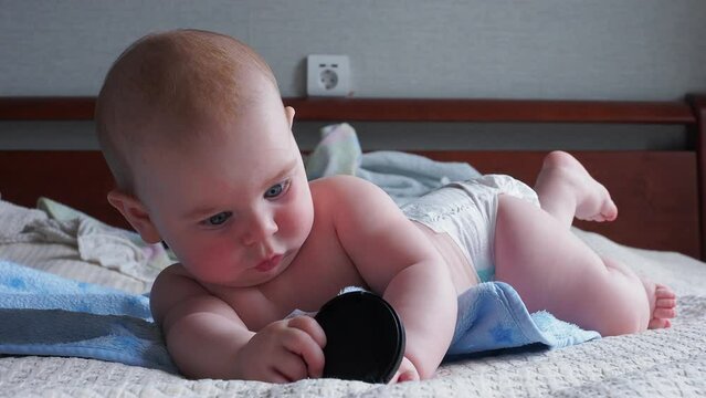 blue toothbrush teether for newborn babies in the baby's mouth holds hands