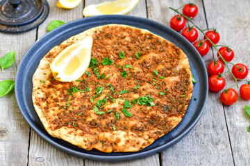  Traditional Turkish cuisine. Baked Pide dish with minced  beef, tomatoes and  herbs on  wooden background.  Turkish pizza pide
