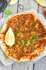  Traditional Turkish cuisine. Baked Pide dish with minced  beef, tomatoes and  herbs on  wooden background.  Turkish pizza pide