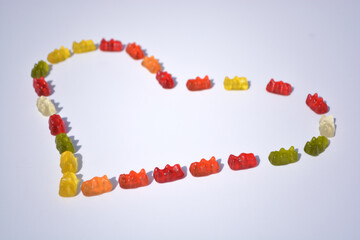 Jelly bears candy on a white background.Gummy bear heart.candy heart.Jelly lowcalorie sweet. Children's dessert.Jelly multicolored bears assorted.Sweet pattern in yellow and red colors.