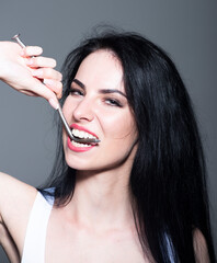 Obraz premium Beautiful white healthy teeth. Dental health. Strong teeth. Healthcare, stomatological concept for dentists. Girl biting metallized nail with healthy white teeth.