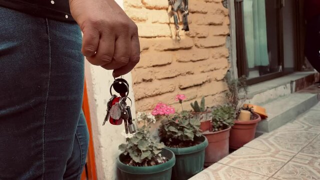 house keys in a woman's hand at the entrance of her house
