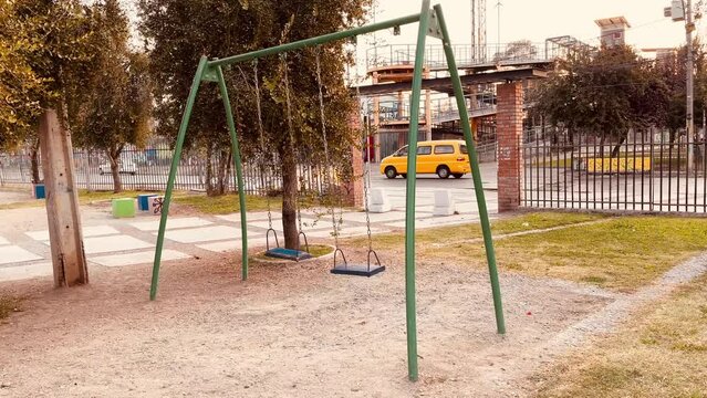 children's play swing swinging in the wind without children playing. located in the park