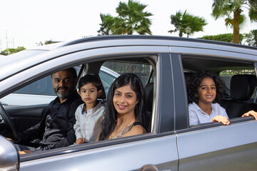 Portrait of happy Indian family inside a car