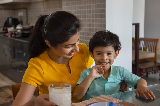 Portrait of mother feeding a glass of milk to her little child