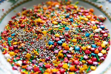 Fototapeta na wymiar Colorful sprinkles on white background, top view. Confectionery decor