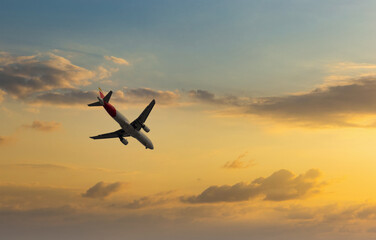 Fototapeta na wymiar Aircraft flyingon a sunset background