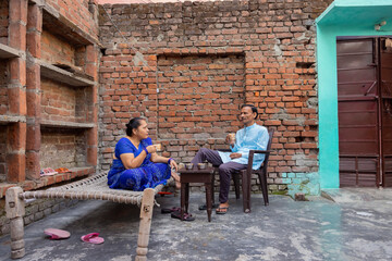 Senior couple talking to each other while having tea in the backyard