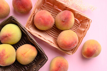 Peach fruit in basket on pink background, Top view