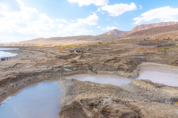 Sinkhole filled with turquoise water, near Dead Sea coastline. Hole formed when underground salt is dissolved by freshwater intrusion, due to continuing sea-level drop. . High quality photo