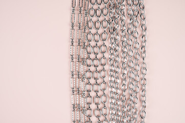 Set of chains on a pastel pink background with copy space. Chain connection, types of metal chains