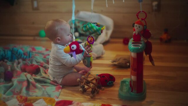 Playful Baby Boy Pulling Toys Sitting On Floor At Home - Fairbanks, Alaska