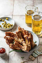 Smoked ribs with rosemary, beer, bottle opener, sauce and olives. Party composition