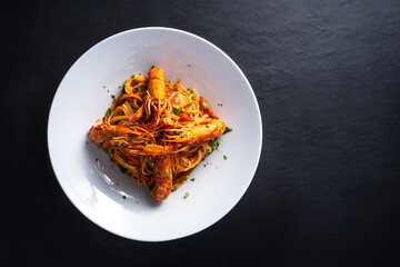 top view plate of shrimp busara spaghetti on dark background