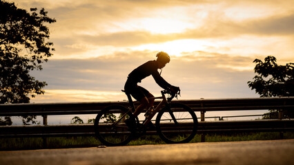 silhouette of a cyclist Cyclist riding bicycle on a mountain at sunrise, Doi Suthep, Chiang mai