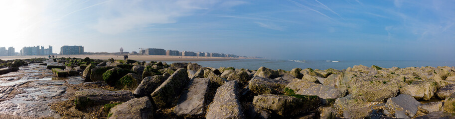 Fototapeta na wymiar panoramic view from breakwater on a misty spring morning on the beach and apartment buildings
