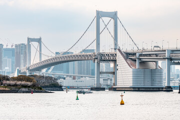Landscape of Rainbow Bridge, the most famous bridge in Tokyo and Odaiba area in a cloudy day