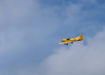 Fototapeta na wymiar Small yellow airplane against a blue sky 