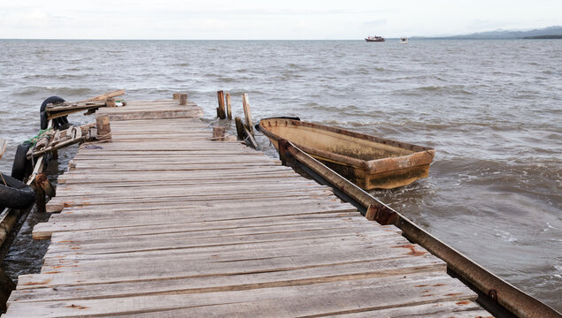 Old boat is moored at wooden pier in Samana bay