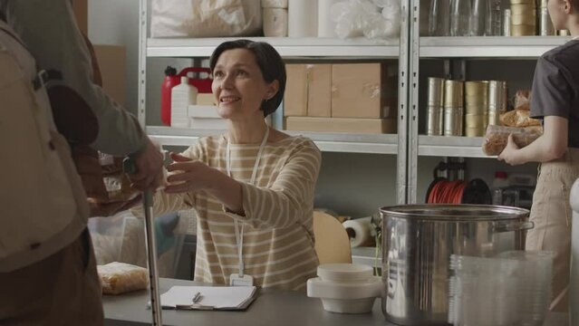 Slowmo of female volunteers giving cereals and other supplies needed to refugees coming for help