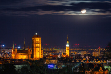 Fototapeta na wymiar A full moon rising over the city of Gdansk at night. Poland