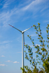 Windmill for electric power production against blue sky. Selective focus.