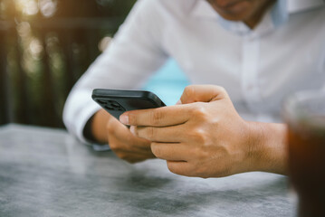 Male business is using a smartphone in the morning.