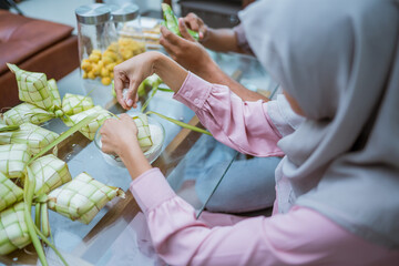Obraz na płótnie Canvas close up gesture of hand making ketupat for eid mubarak