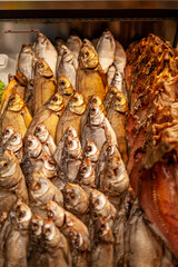 Obraz premium Fish shop: close-up of smoked and dried fish laid out in a shop window. 