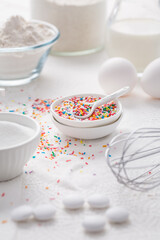 Baking background with flour, eggs, sugar sprinkles, kitchen tools, utensils