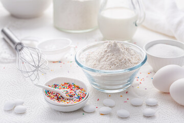 Baking background with flour, eggs, sugar sprinkles, kitchen tools, utensils