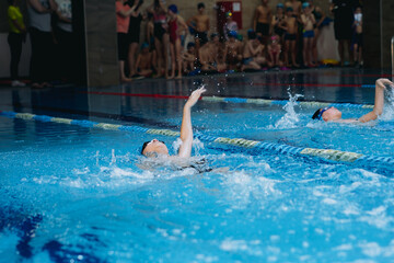 children athletes competing in the swimming pool.