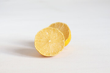 Cut in half juicy fresh lemon on white table. 