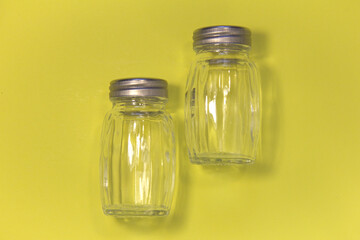 Empty salt shakers. On a yellow background.