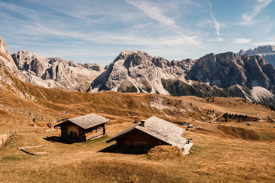 Seceda. Majestic landscape of Alpine red autumn nature Seceda. Wonderful hiking nature scenery in dolomites. Wooden chalets in Dolomites, Odle mountain range, Val Gardena. Majestic Furchetta peak