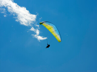 Paraglider that flies from a top of the Intelvi Valley, with a view of the Swiss Alps and Lake Lugano. Concept of lifestyle, freedom and extreme sport adventure.