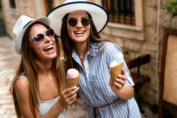 Happy young women friends enjoying ice cream together on summer vacation