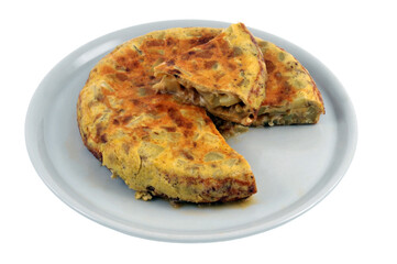 Omelette espagnole dans une assiette avec une part coupée vue de dessus sur fond blanc