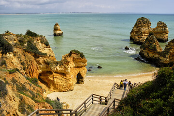 cliff and rocks and wooden footbridge to the beach Praia do Camilo, in Lagos, Algarve, Portugal	