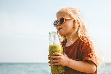 Child drinking smoothie outdoor healthy lifestyle summer vacations reusable glass bottle vegan beverage organic food