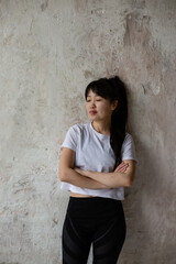 cute Asian girl with dark long hair is standing at the crafting wall 