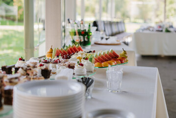 Various desserts and cake on the buffet table at the wedding