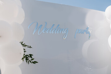 White photo zone decorated with balloons at the wedding