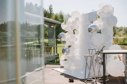 White photo zone decorated with balloons at the wedding