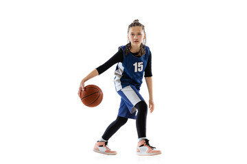 Portrait of teen girl, basketball player in motion, dribbling ball isolated over white studio background