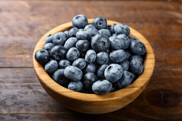 Fresh blueberries in a wooden bowl. Healthy and dietary food concept.