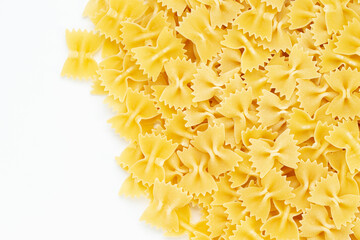 Raw farfalle pasta on white background a lot of dry pieces.