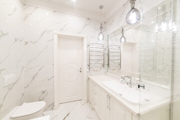 new bathroom interior in a house with white tiles, a large mirror and a white sink