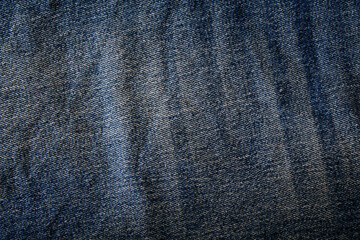 Dark blue fabric texture of old wrinkled jeans